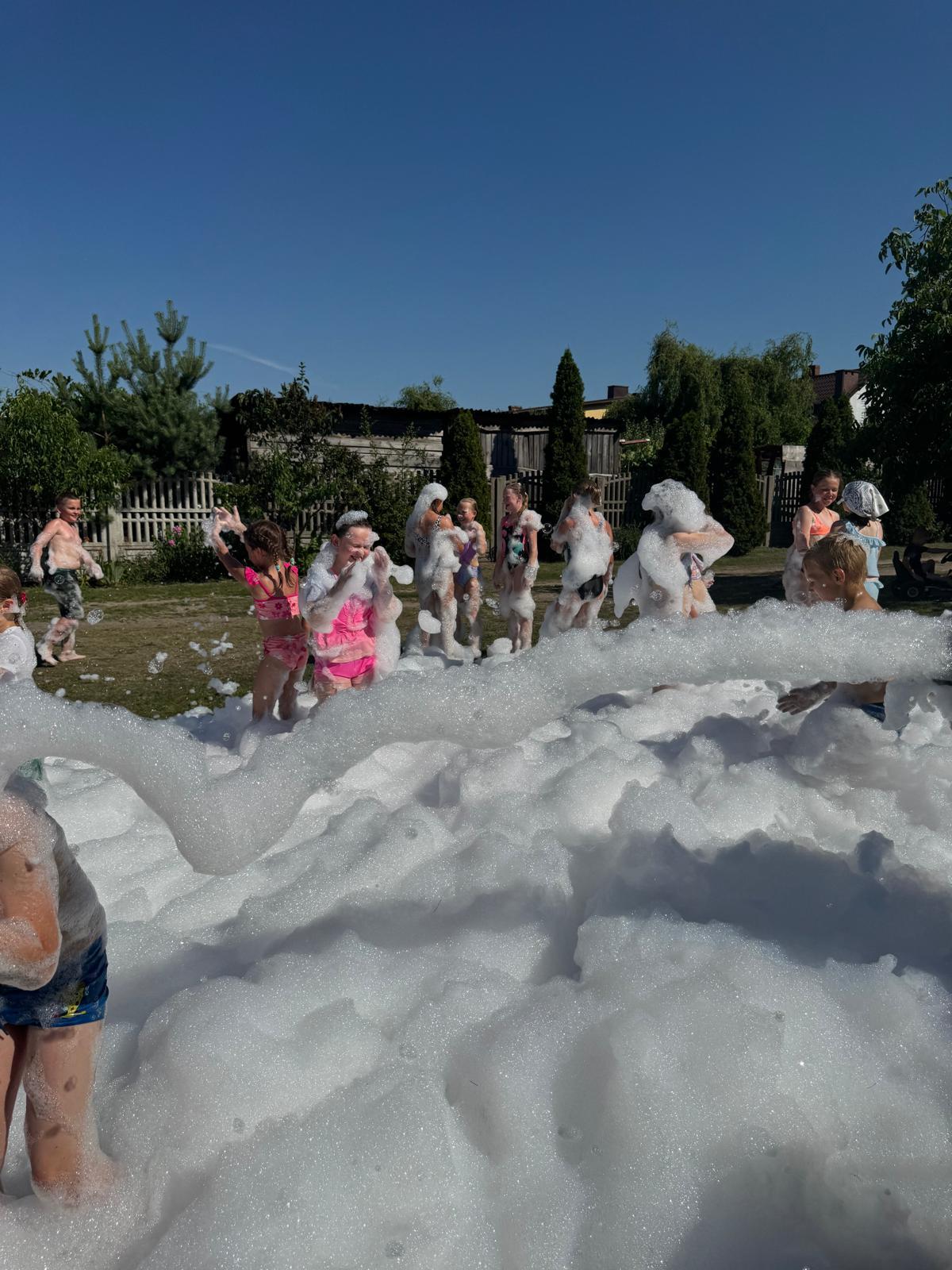 Dzieci bawiące się w gęstej pianie podczas piana party