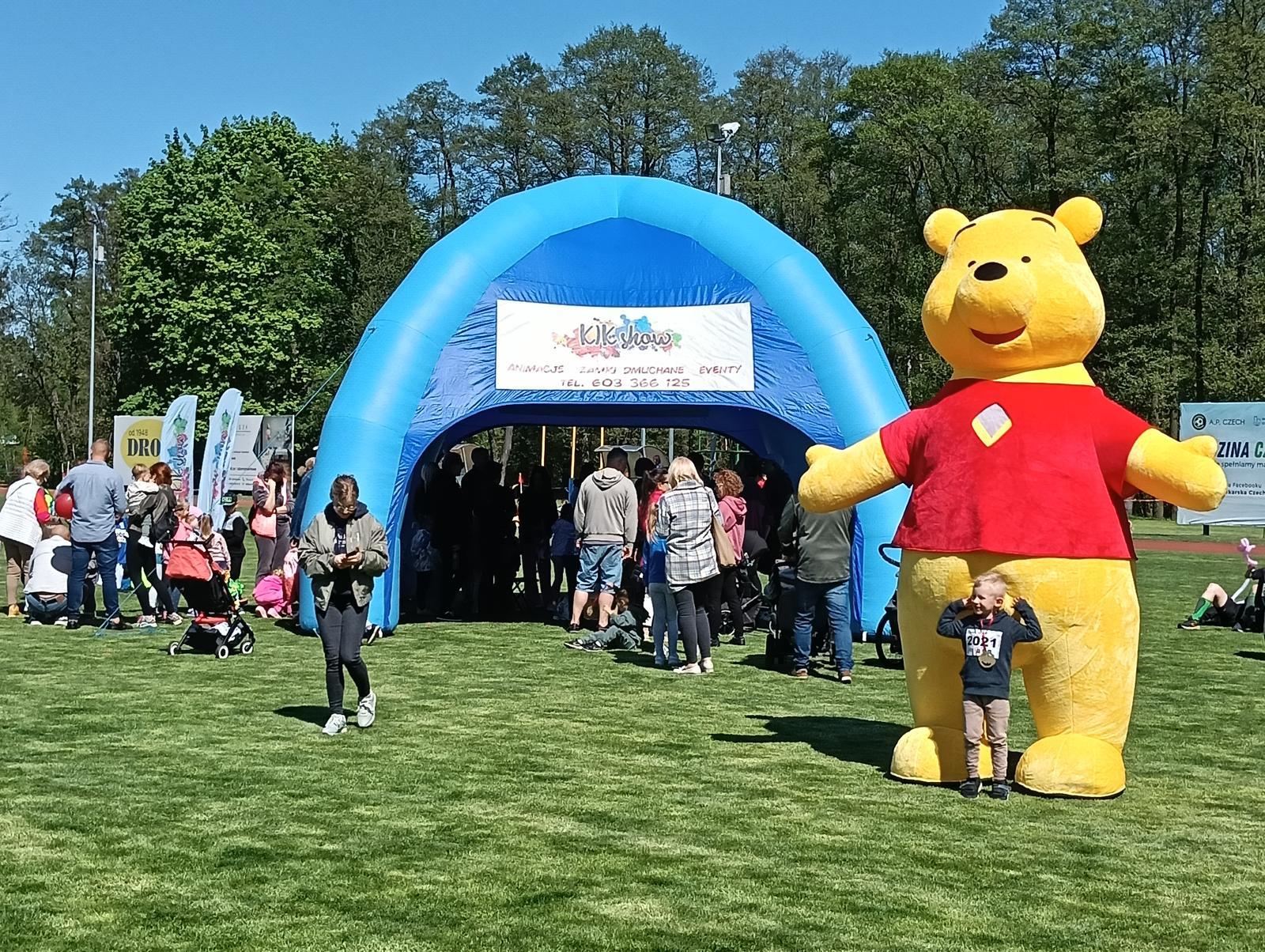 Stoisko KIK Show z dmuchanym namiotem i maskotką gigant podczas imprezy plenerowej